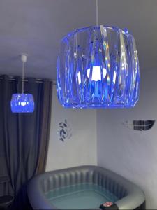 um lustre de vidro azul pendurado no tecto em Jacuzzi au cœur de Bordeaux em Bordeaux