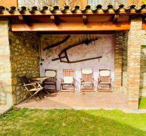 eine Terrasse mit einem Tisch und Stühlen unter einem Dach in der Unterkunft Masia Pau Prat in Lliçà d'Amunt