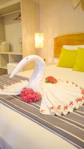 a bed with a swan made out of flowers on it at Baía Branca Beach Resort in Tamandaré