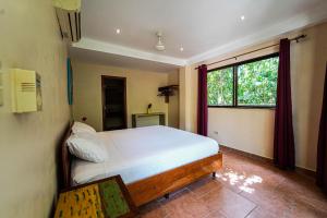 ein Schlafzimmer mit einem großen Bett und einem Fenster in der Unterkunft Sol y Sombra in Bocas del Toro