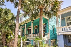 una casa verde con palme di fronte di Vintage Galveston Apt Less Than half Mi to Porretto Beach! a Galveston