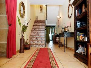 sala de estar con escalera y alfombra roja en Casa rural marga, en Tardienta