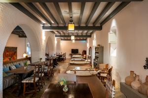 a restaurant with wooden tables and chairs and a room with tables at Parador de Almagro in Almagro