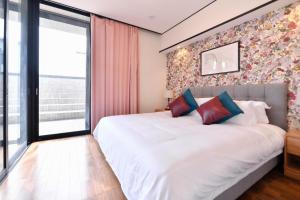 een slaapkamer met een groot wit bed en een raam bij BRUCE HOUSE - Vacation STAY 9370 in Izumi-Sano
