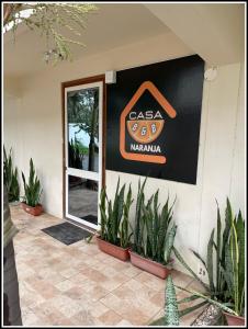 a sign on the side of a building with plants at Bed and Breakfast La Casa Naranja in Olón