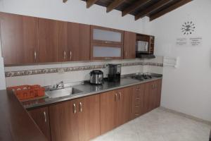 cocina con armarios de madera, fregadero y microondas en Apartamento en Envigado, en Envigado