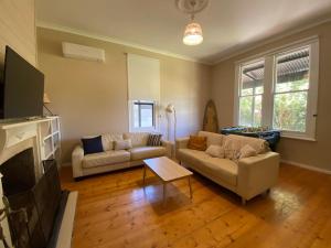 un soggiorno con due divani e un camino di Large Coastal Cottage a Inverloch