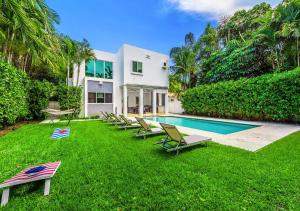 una casa con un cortile con sedie e una piscina di Exotic 5 Bedroom Villa In South Miami a Miami