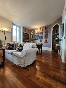 - un salon avec un canapé blanc et du parquet dans l'établissement Apartment Bonnard - best view in Dijon, à Dijon