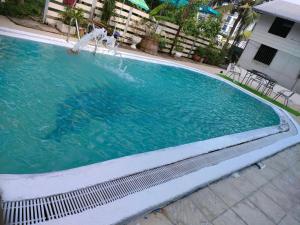 a swimming pool with a fountain in a building at Anmol Hotel Thai Smile Group in Pattaya Central