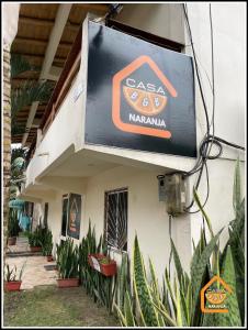 a sign on the side of a building with plants at Bed and Breakfast La Casa Naranja in Olón