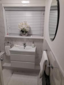 uma casa de banho branca com um lavatório e um espelho em Liverpool Air b and b em Sefton