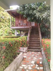 a staircase leading up to a house with flowers at Casa del Campo in Tela