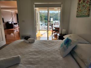 a bedroom with a large bed and a living room at A Slice of Paradise in Barnes Bay