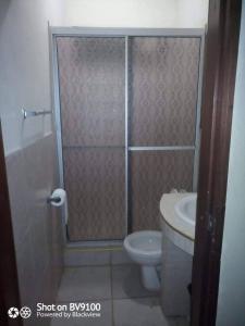 a bathroom with a shower with a toilet and a sink at Casa del Campo in Tela