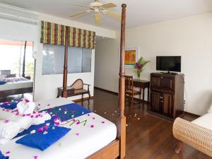 Un dormitorio con una cama con flores. en Blue Haven Hotel - Bacolet Bay - Tobago, en Scarborough