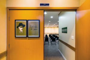 馬林加的住宿－HUS Hotel MARINGA，一条走廊,上面有三张带帽子的男人的照片