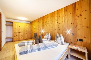 two beds in a room with wooden walls at Residence Kalchgruberhof Zirbe in Santa Valpurga