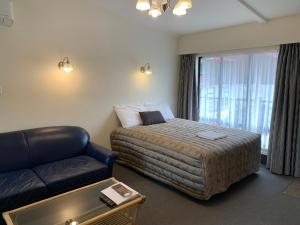 ein Hotelzimmer mit einem Bett und einem Sofa in der Unterkunft 755 Regal Court Motel in Dunedin