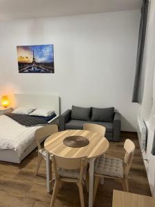 een kamer met een tafel, een bed en een bank bij Paris Apartments in Katowice