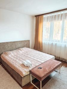 Schlafzimmer mit einem Bett mit einem Tisch und einem Fenster in der Unterkunft Apartman Petunija in Sjenica