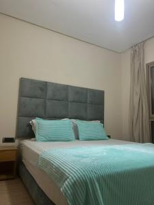 馬拉喀什的住宿－Prestigia golf piscine appartement lux opale 3 chambre，一间卧室配有一张带蓝色枕头的大床