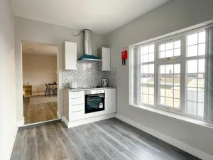 a kitchen with white cabinets and a large window at Stay Inns in Birmingham