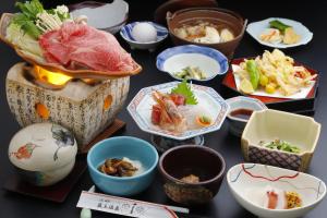 un gruppo di piatti di cibo su un tavolo di Takasagoya Ryokan a Zaō Onsen