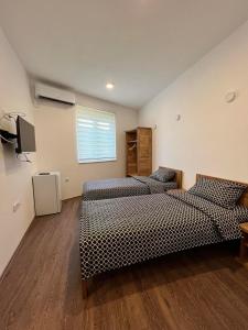 una camera con due letti e una televisione in esso di Apartmani BJELASICA a Bijelo Polje