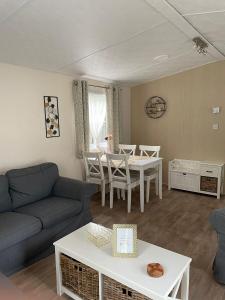ein Wohnzimmer mit einem Sofa und einem Tisch in der Unterkunft Casa Nymphaea in Kinrooi