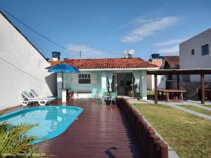 un patio trasero con piscina y una casa en casa piscina pinheira -sc, en Palhoça