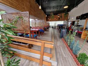 a restaurant with wooden benches and tables and plants at Rooms & Spa BJELASICA in Bijelo Polje