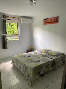 een slaapkamer met een bed in een kamer met een raam bij f3 location saisonnière détente tranquillité et belle vue in Les Trois-Îlets