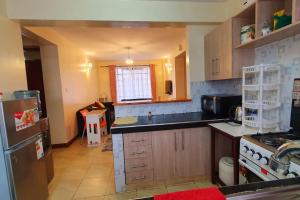 a kitchen with a refrigerator and a counter top at Spacious 2bedroom condo w free parking on premises in Nairobi