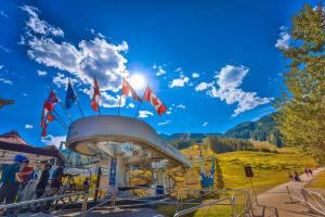 a ride at a ski resort with flags on it at Aurora Townhomes by StayIn in Panorama