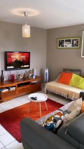 een woonkamer met een bed en een televisie bij f3 location saisonnière détente tranquillité et belle vue in Les Trois-Îlets