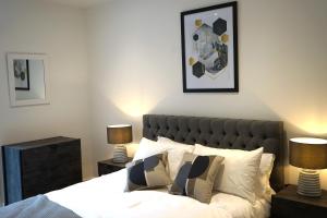 ein Schlafzimmer mit einem Bett mit zwei Nachttischen und zwei Lampen in der Unterkunft Exceptional 1King Lifestyle Apartment - Centrally located in Birmingham