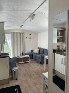 ein Wohnzimmer mit einem blauen Sofa und einem Tisch in der Unterkunft Casa Nymphaea in Kinrooi