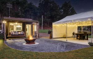 a tent with a fire in a yard at night at Laid Back Manor, luxury and private golf in Kaoota