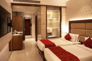 Cette chambre comprend deux lits et une salle de bains. dans l'établissement Hotel Gurudev Grand, à Kalyan