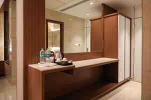La salle de bains est pourvue d'un lavabo et d'un miroir. dans l'établissement Hotel Gurudev Grand, à Kalyan