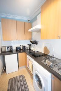 a kitchen with a washing machine and a washer at Sandgate 2-Bed Apartment in Ayr central location in Ayr