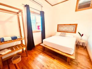 a bedroom with a white bed and a window at Casa Le Parc - Main Street in Bocas Town