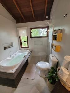 ein Bad mit einer Badewanne und einem WC in der Unterkunft Refugio Na Praia Hospedagem - Guarda Do Embaú in Guarda do Embaú