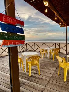 een rij tafels en gele stoelen op een pier bij Pousada Casa Do Alemão in Flecheiras
