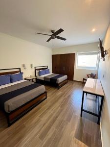 sypialnia z 2 łóżkami i wentylatorem sufitowym w obiekcie Hotel Refugio w mieście San Juan de los Lagos
