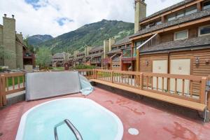 a hot tub on a patio next to some buildings at Horsethief Lodge by FantasticStay in Panorama