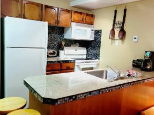 a kitchen with a white refrigerator and a sink at Horsethief Lodge by FantasticStay in Panorama