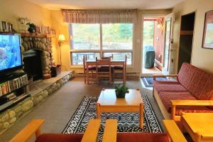 a living room with a couch and a table at Horsethief Lodge by FantasticStay in Panorama