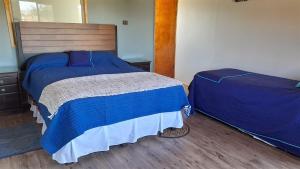 a bedroom with two beds and a mirror at 100 Experiencias Chile, habitación 3 in Lagunillas